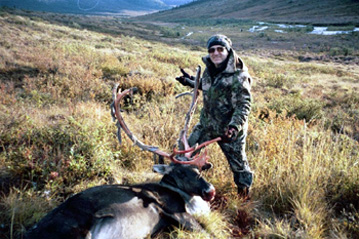 Downed caribou and Neil with camp in background